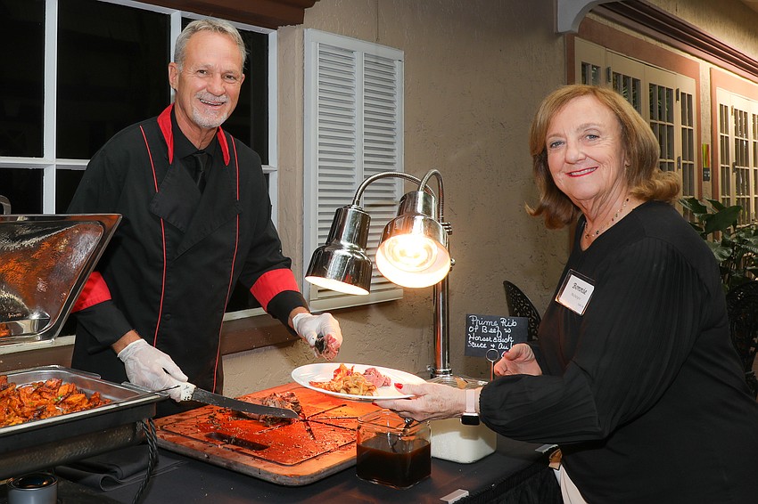 Chef Jimmy Shawver serves prime rib to guest supporter Bonnie McIntyre.
