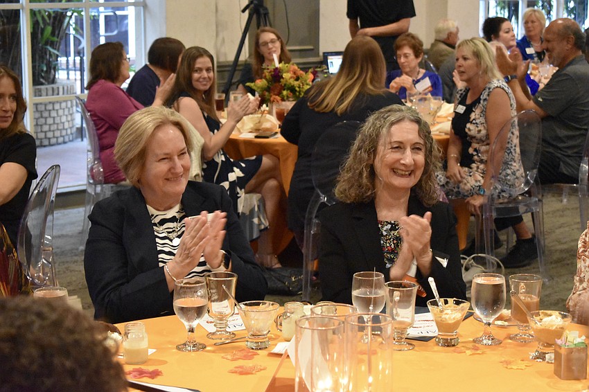 Julie Leach and Penelope Kingman of Westcoast Black Theater Troupe applaud during the ceremony.