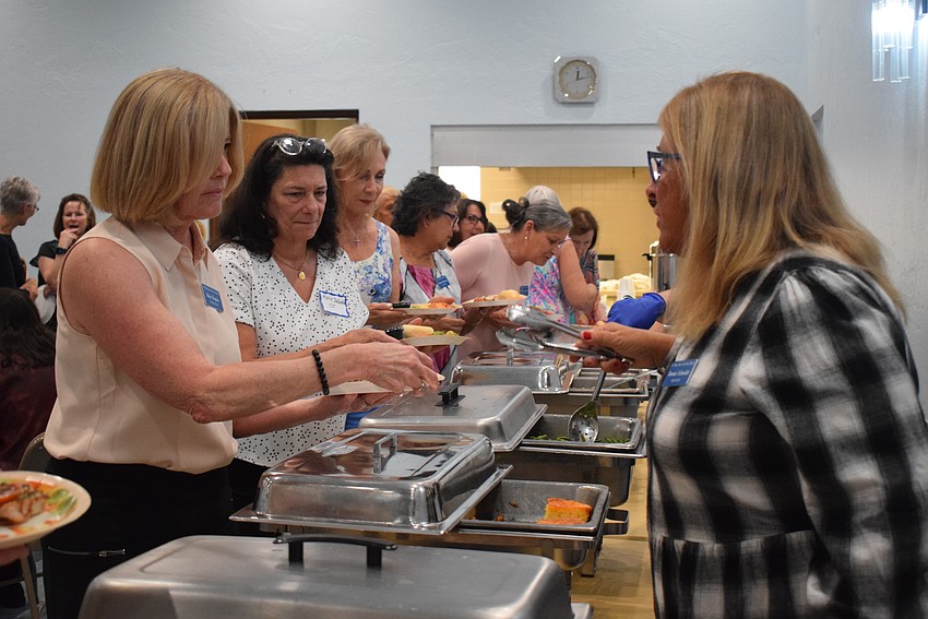 Mary Kupiec getting food from Bonnie Schneider at the St Mary Star of the Sea Women's Guild