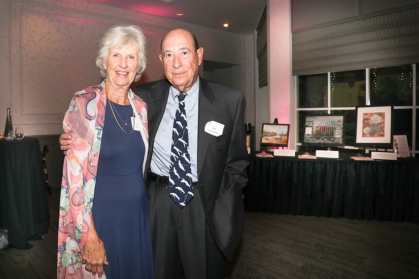 Carol Somers and Joe Bornstein with the artwork contributed to the silent auction.