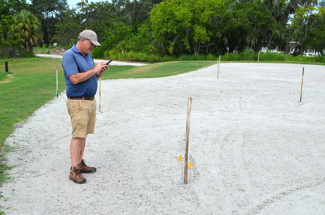 Richard Mandell consults his Donald Ross notes while walking a green during the restoration of the Bobby Jones Golf Course in June 2023.