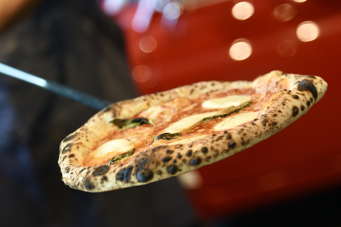 Braulio Vizcaino pulls a Margherita pie out of Osteria 500's trademark red Fiat pizza oven.