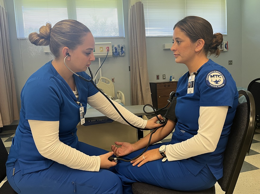 Kailee Looman and Andrea Evans, LPN students at Manatee Technical College, practice taking each other’s blood pressure.