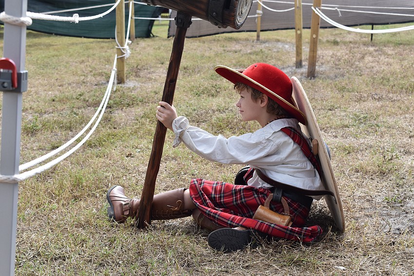 Tuck Brunketurner, 9, a member of the festival's travelling crew, watches as attendees engage in a battle through Sword Master's Challenge.