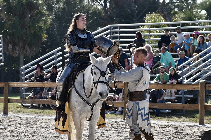 Sir Lilith (Erin Eisenmann) receives her jousting helmet from Sir Lucian.