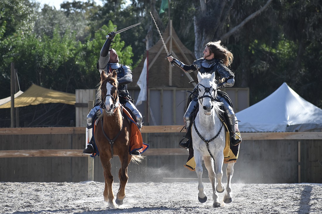 Sir Lilith (Erin Eisenmann) and Sir Michael (Michael Murphy) face off against one another in a sword fight on horseback.