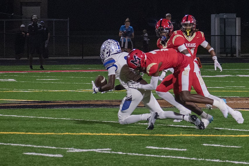 Cardinal Mooney senior Zy'marion Lang (7) makes a tackle on a Lakeland Christian receiver.