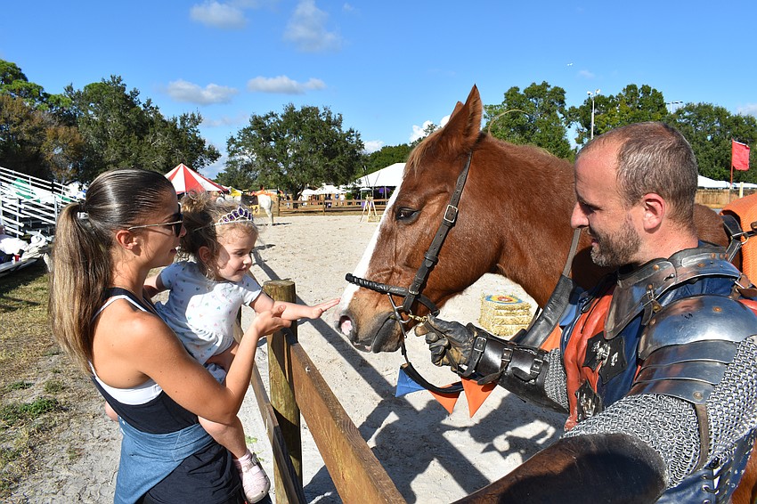 Gabby Sriota and Lily Sriota, 2, meet the horse of Sir Michael (Michael Murphy).