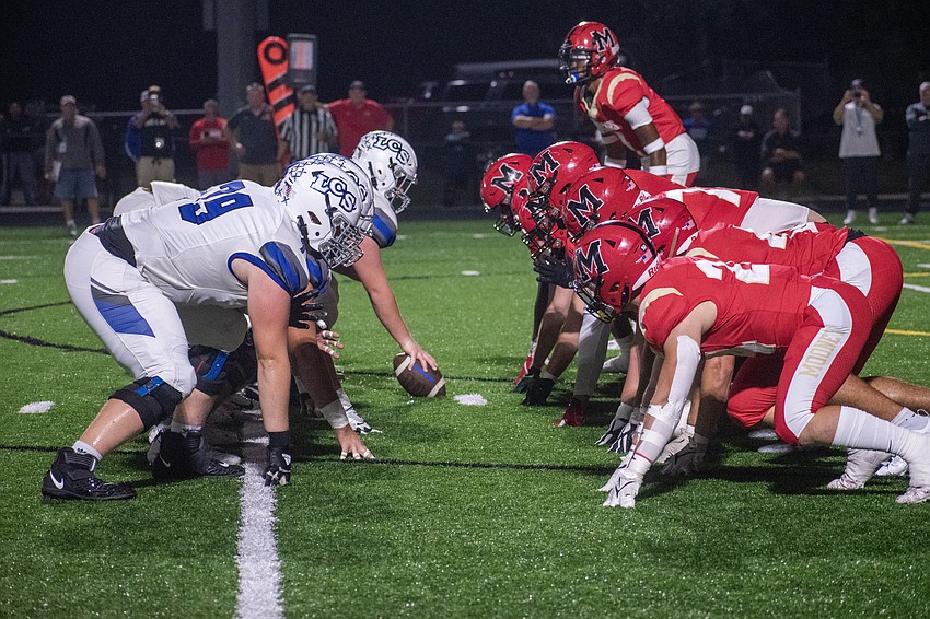 The Cardinal Mooney defensive front digs in against Lakeland Christian prior to a snap.