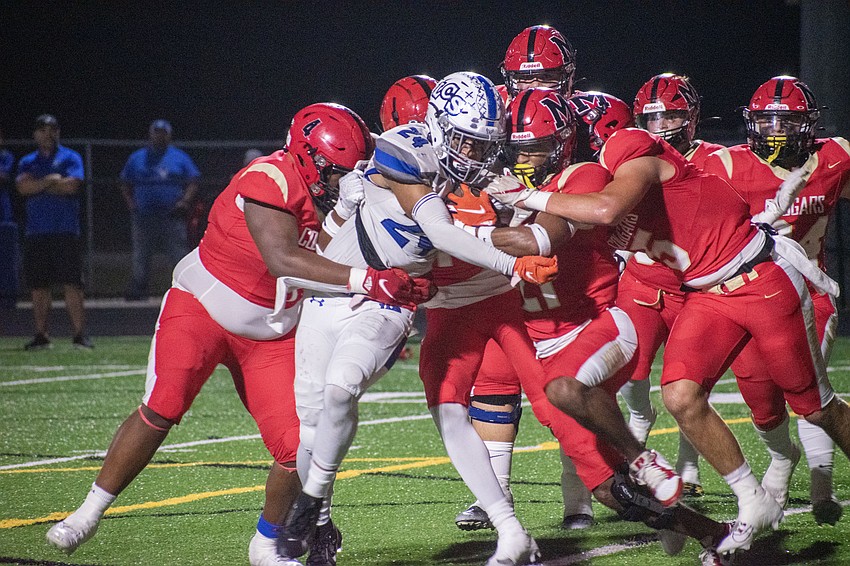 The Cardinal Mooney defense swarms to bring down Lakeland Christian junior Killian O'Neal.