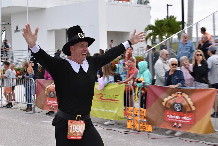 Venice's Adam Pennell celebrates like a pilgrim at the finish line of the Florida Turkey Trot on Thanksgiving morning at Nathan Benderson Park. Pennell, who weighs 215 pounds, says he is thankful he has lost 175 pounds.
