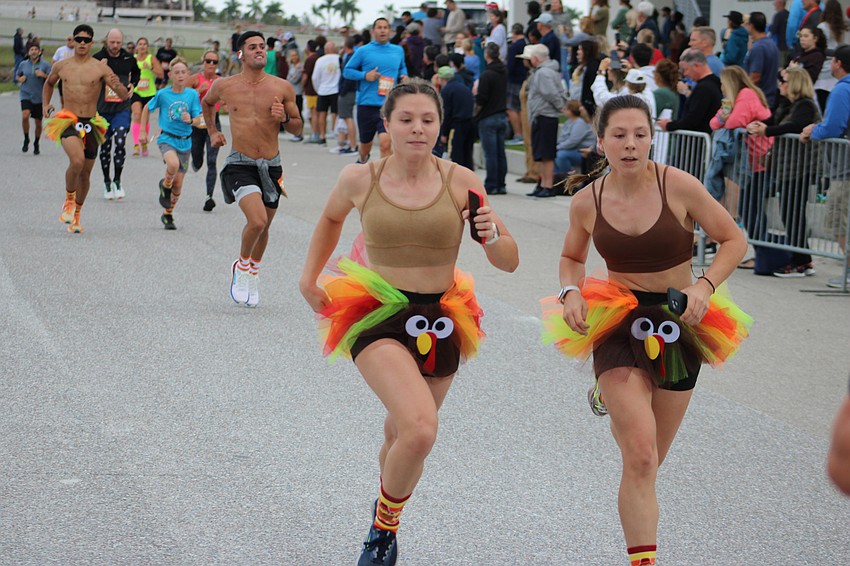 Amelia Rusch and McKenzie Rusch, 16-year-old Braden River High cross country runners, are all business as they finish the last few yards of the Florida Turkey Trot at Nathan Benderson Park.