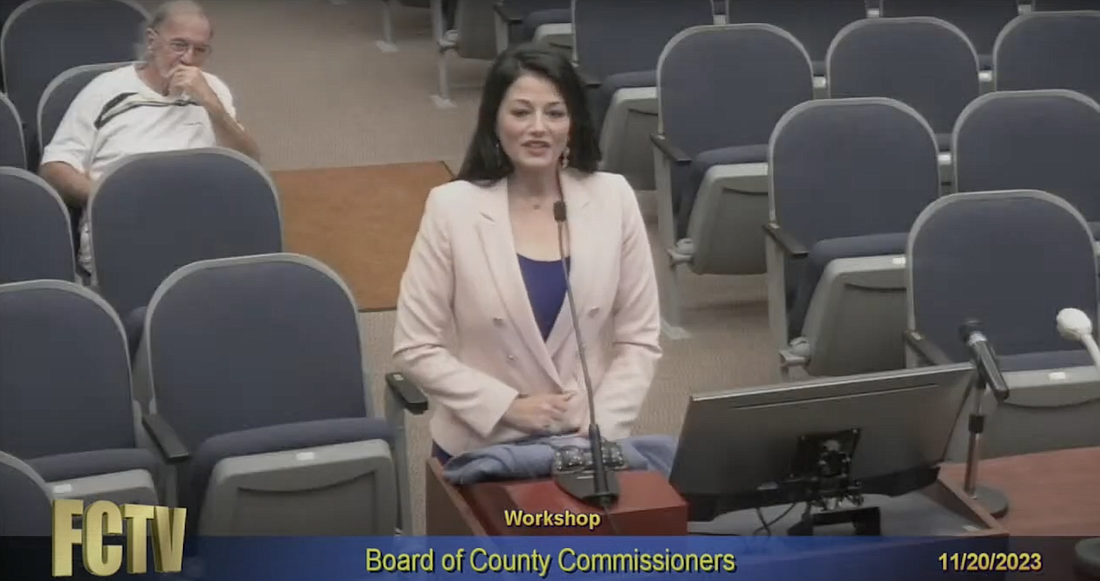 Heather Haywood, speaking, with Jeff Davies in the background. Photo from County Commission meeting video