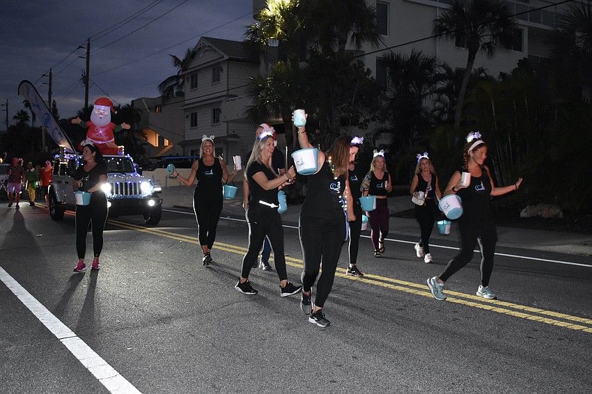 Representatives of Tranquility by the Sea dance along Beach Road.