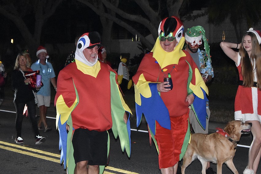 Tom Dodge and Brian Usher walk in the parade as parrots, representing Siesta Key Wine Bar.