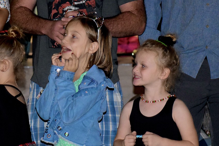 Allie Minzey, 7 and Aubree Pinnix, 5, become enthusiastic as Santa Claus arrives.