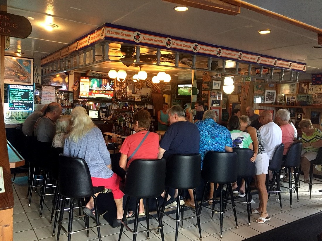 Customers gather around the bar area at Martin’s during happy hour, with the chandelier hanging overhead, on Aug. 22, 2017. Photograph courtesy of Lupe Martin