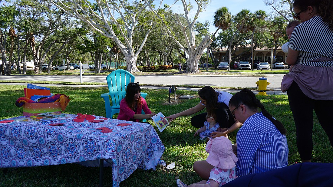 Ray Grace reads a children's book to the three who attended the Nov. 21 Pop-up Library children's activities.