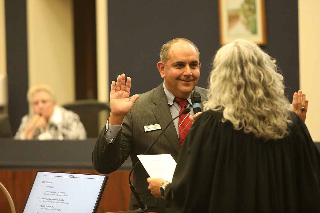 Will Furry takes the oath of office as Flagler County School Board chair as outgoing Chair Cheryl Massaro watches in the background. Photo by Brent Woronoff