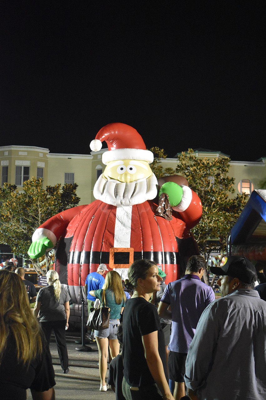 A giant Santa towers over Lakewood Ranch Main Street. There's a bounce house inside his belly.