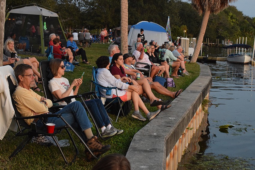 People line the river in anticipation of the Holiday Boat Parade at Jiggs Landing.