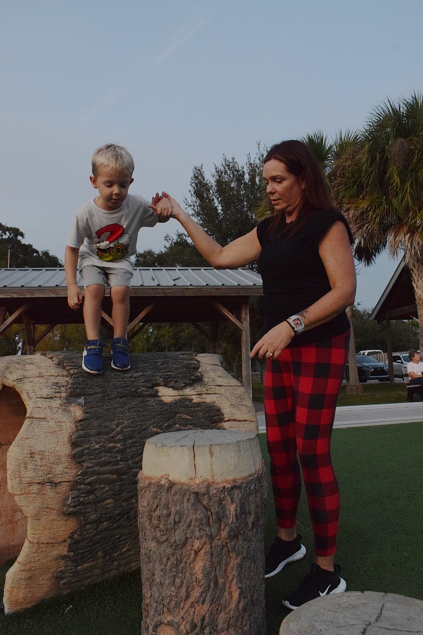 Bradenton 4-year-old Carter Andrzejewski plays with Carrie Cook. She helps him jump from log to log.