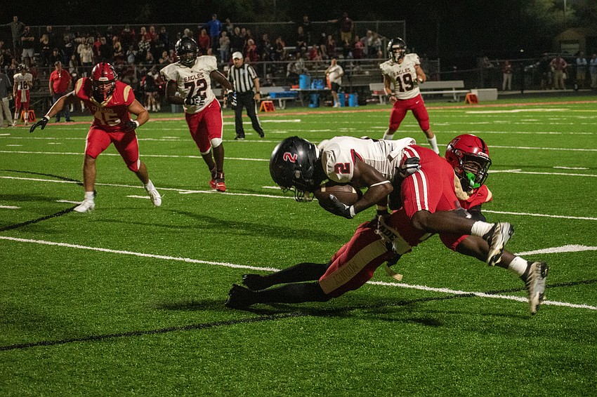 Cougars senior Zy'marion Lang upends NFC receiver Major Hart II.