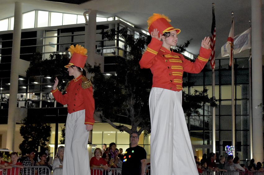 Circus Arts Conservatory students Jocelyn Williams, 13, and Tasman Henry, 16, tower above the crowds on stilts.