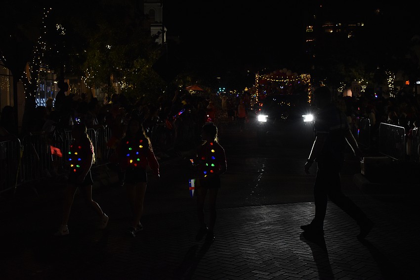 Participants in the parade wear strands of Christmas lights.