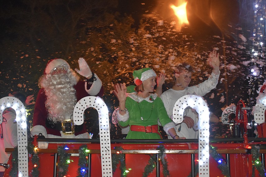 Santa Claus arrives, with Tara and Cooper Middleton, aboard the fire truck.