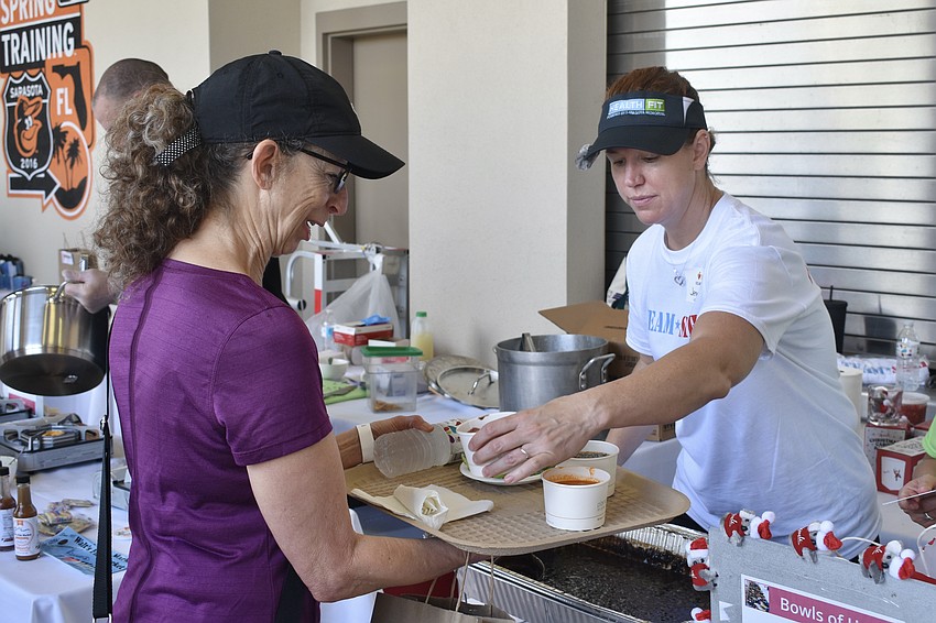 Mary Boutieller accepts soup from Jennifer Otero of Team SMH.