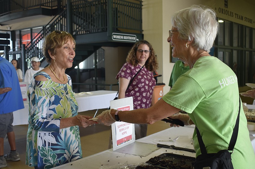 Marge Flynn accepts a brownie from Jan Gannon.