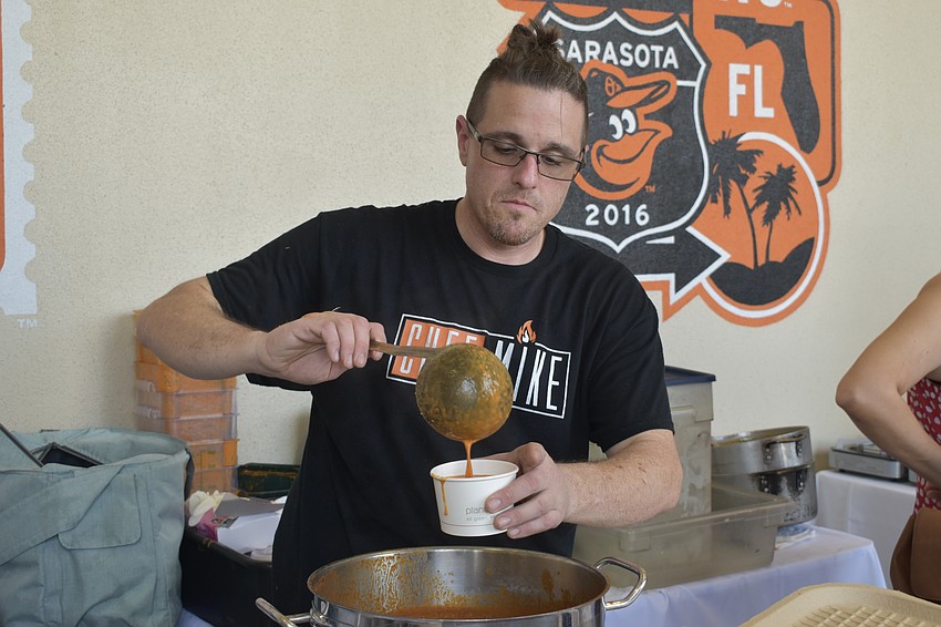 Mike Donnerstag of Chef Mike's Catering spoons soup into a bow.