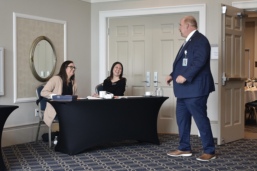 Maggie Burton and Lisa Wood greet Craig Maniglia, communications and community relations director at Sarasota County Schools.