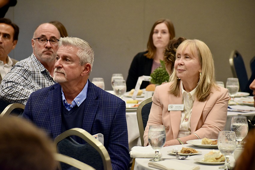 School board member Tom Edwards and school board chair Karen Rose watch Terry Connor's presentation.