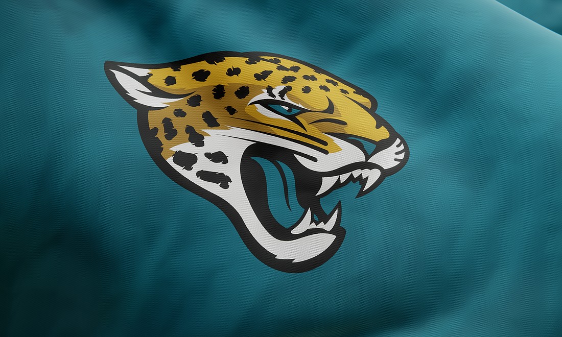 NFL team Jacksonville Jaguars logo on waving jersey fabric. Editorial 3D rendering