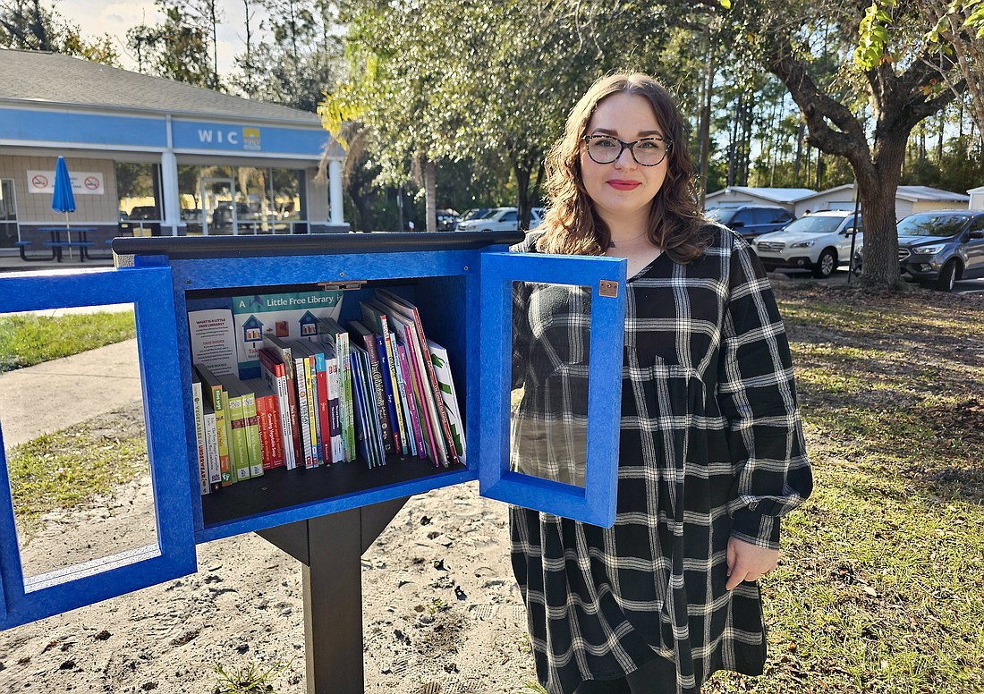 Mary Kauffman, a Department of Health-Flagler senior health educator, with the DOH-Flagler's new “Big Blue Box," a registered free library with the nonprofit Little Free Libraries. Photo by Sierra Williams