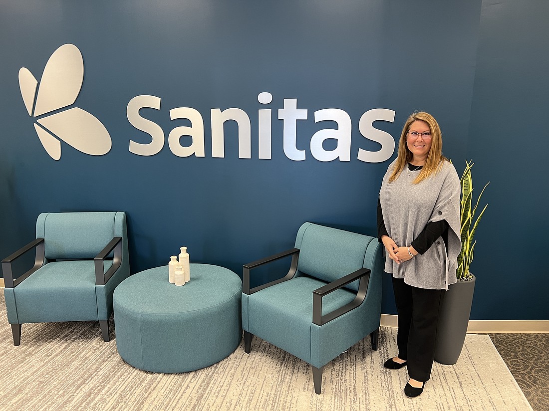 Alicia Zoya, GuideWell Health director of Clinical Services, shows a model of the  Sanitas Medical Center waiting room. Florida Blue has a sales office near the Sanitas that includes mock-ups of the new clinic.