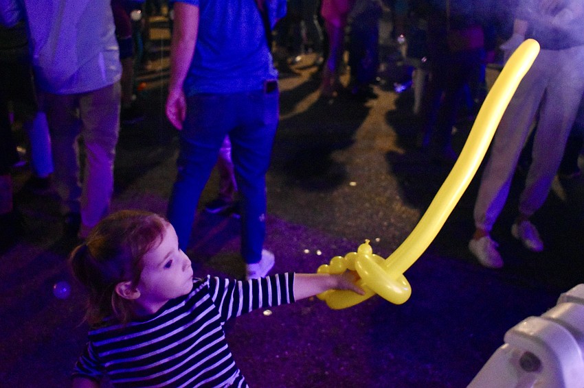 Aubrie Ross, 2, lets her balloon sword take the lead as she inches closer to the smoke machine.