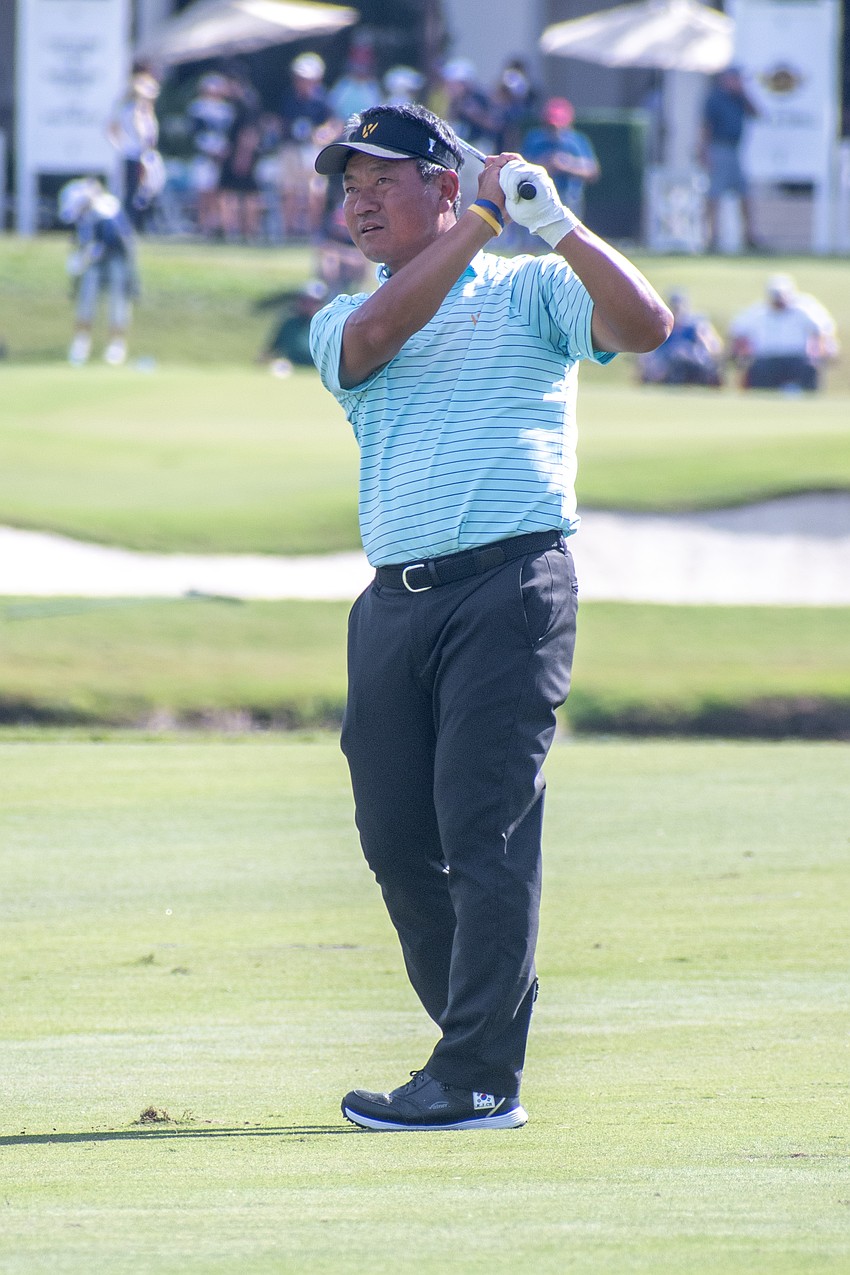 Team International's K.J. Choi hits his second shot on the No. 1 hole at The Concession Golf Club on the final day of the World Champions Cup. Choi would par the hole and earn one point.