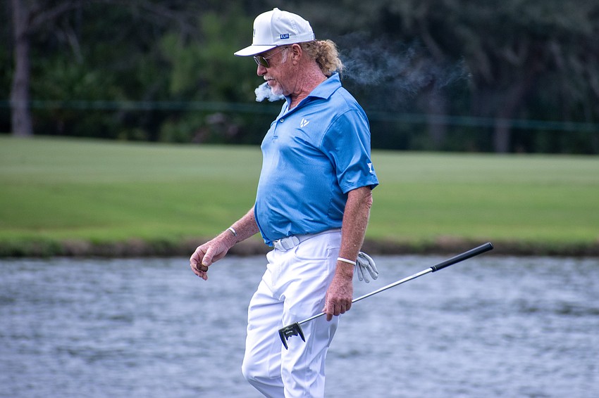 Team Europe's Miguel Angel Jimenez takes a puff of a cigar while walking down the No. 9 hole at The Concession Golf Club on the final day of the World Champions Cup.