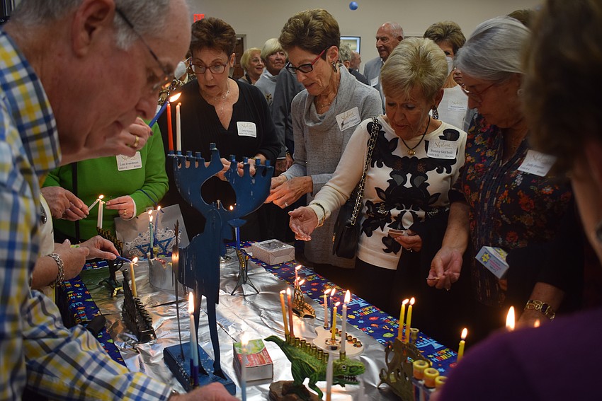 Temple Beth Israel members Deb Nyman, Carole Cohen, Bunny Skirboll and Judy Ponser lighting their menorahs.