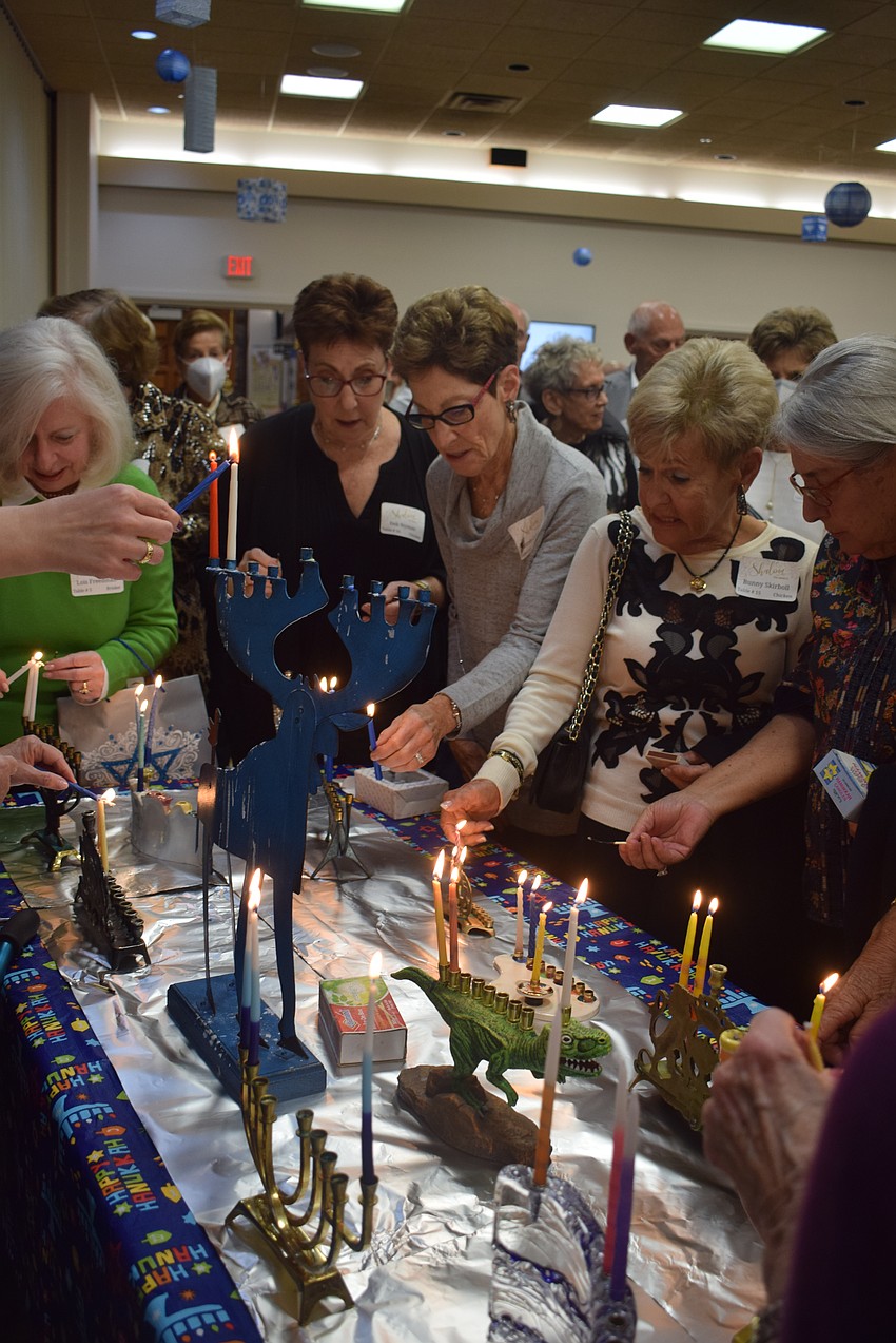 Temple Beth Israel members Deb Nyman, Carole Cohen, Bunny Skirboll and Judy Ponser lighting their menorahs.
