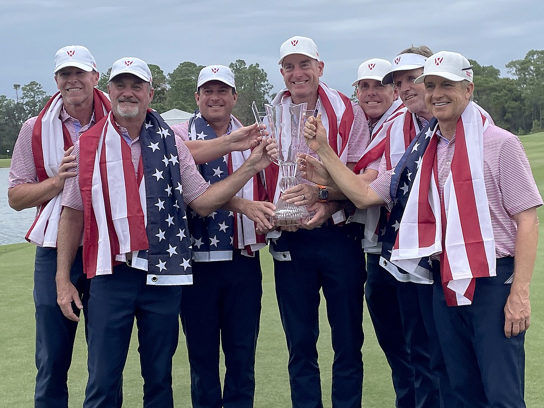 Steve Stricker, Jerry Kelly, Billy Andrade, Jim Furyk, Justin Leonard, Brett Quigley and David Toms hold the World Champions Cup trophy aloft after winning it as Team USA.