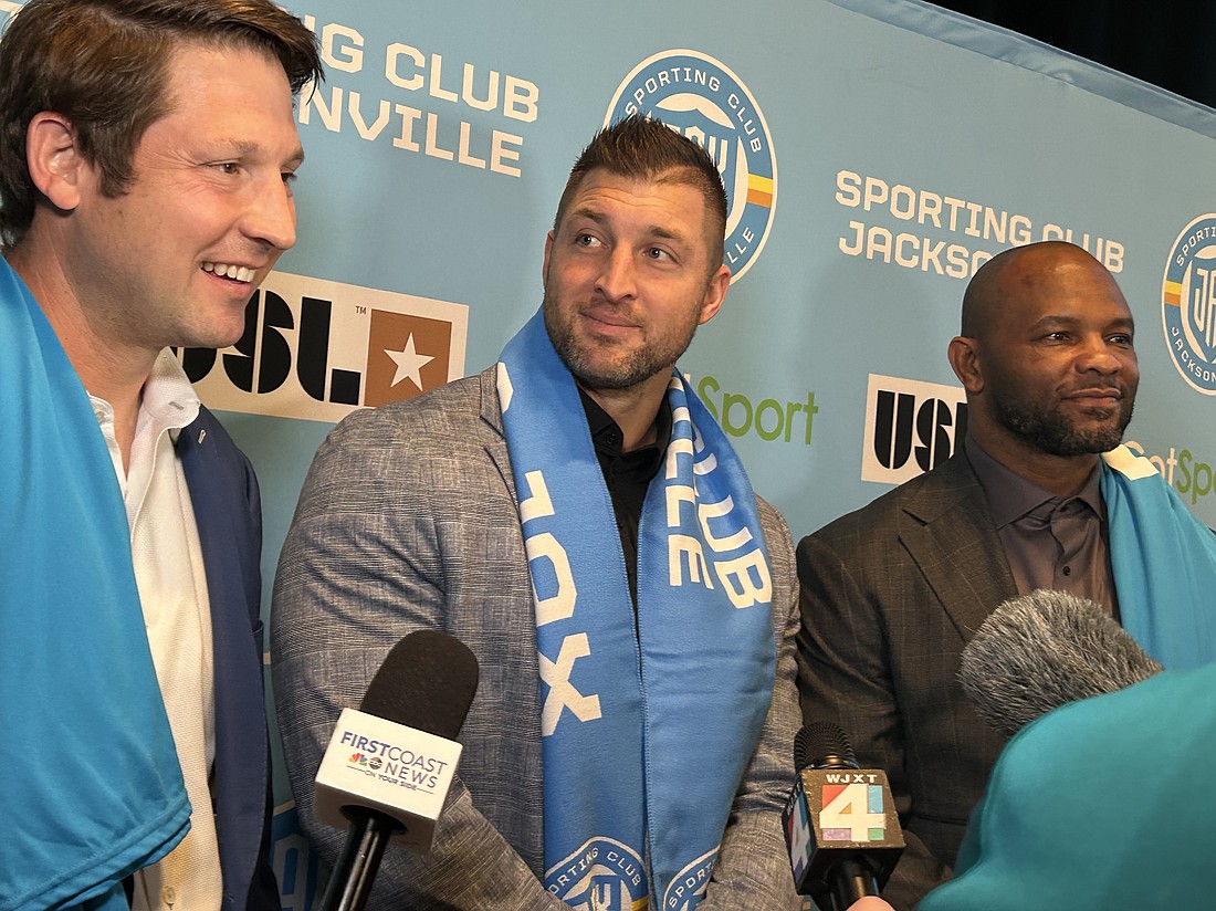 Ricky Caplin, Tim Tebow and Fred Taylor answer questions from news organizations after the JAXUSL soccer club announcement event Dec. 12.