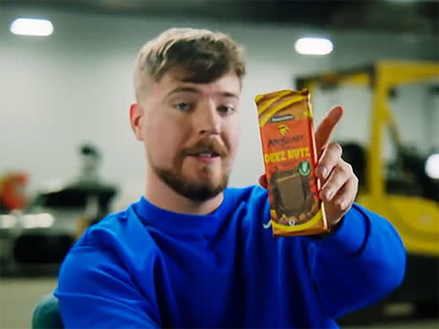YouTube star Jimmy Donaldson, better known as MrBeast, shows off his Deez Nutz Peanut Butter Milk Chocolate bar in an ad for the product sold by his Feastables brand.