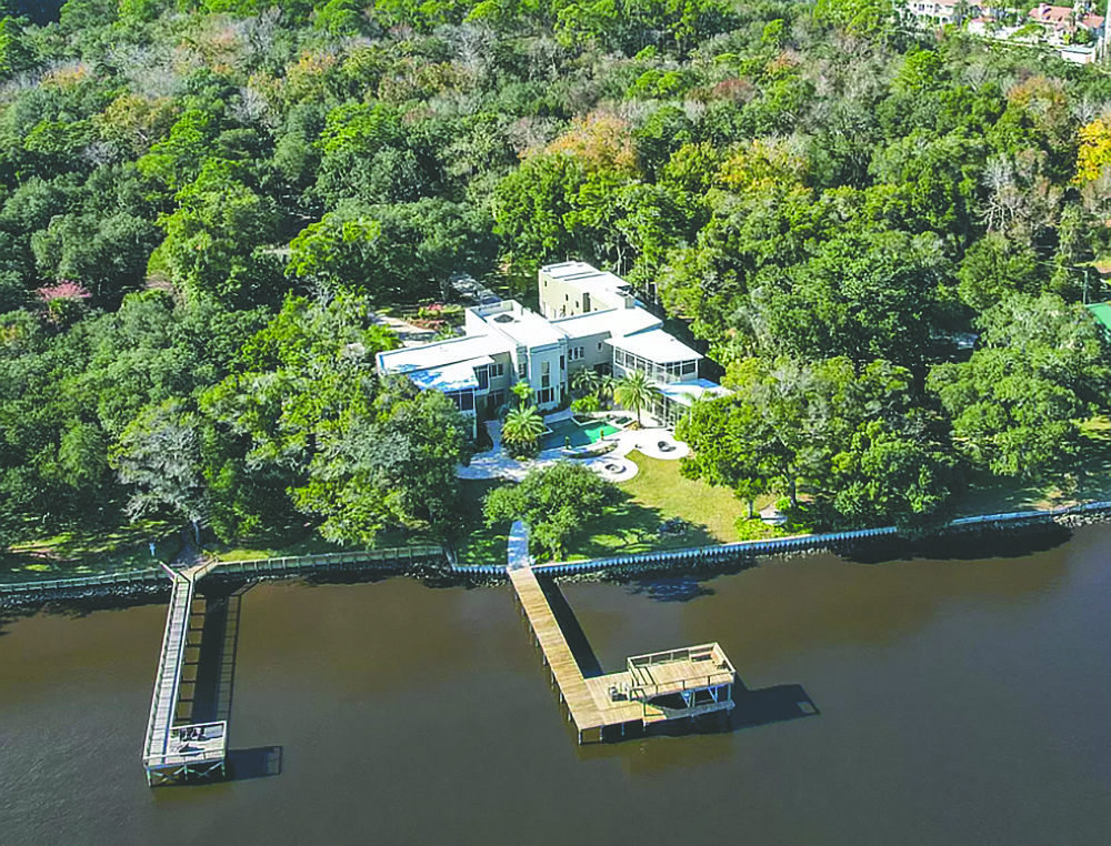 Two-story home on the Intracoastal Waterway features five bedrooms, five full and four half-bathrooms, two offices, gym, media room, wine cellar, elevator, screened porches and patios, detached shop building, saltwater pool, dock and boatlift.