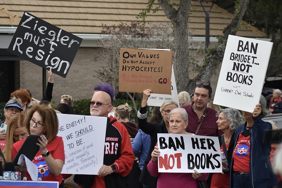 Protesters hold signs during the rally.
