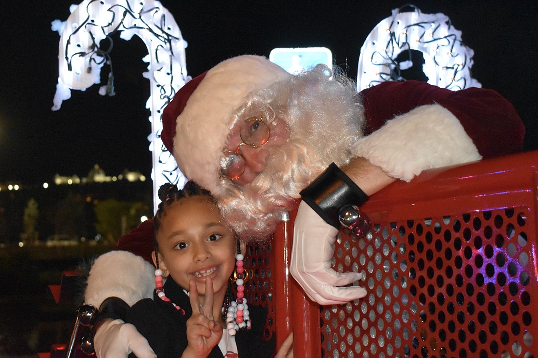 Chloe Marino, 7, meets Santa Claus at the Downtown Sarasota Holiday Parade on Dec. 2, 2023.
