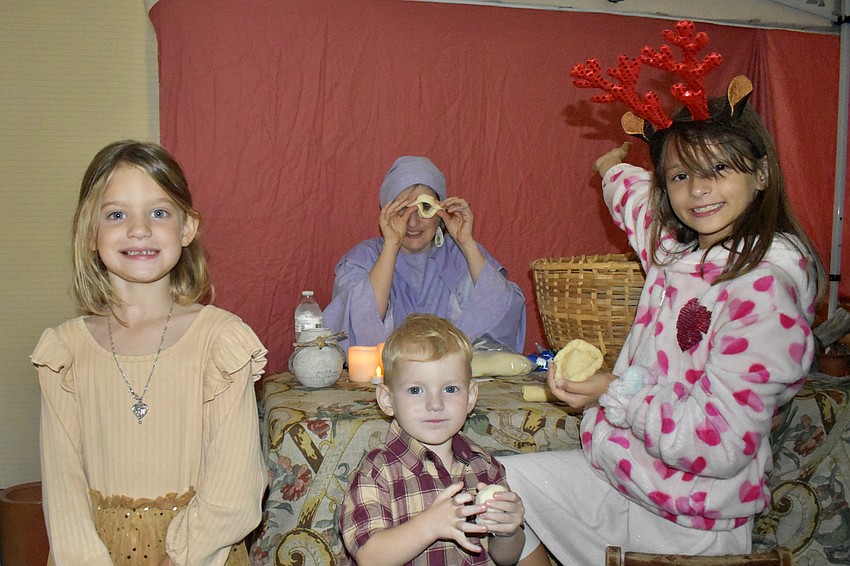 Alice Mahaffey, 5, Jackson Mahaffey, 3 and Audrey Vargas, 8, learn from Jessica Brunette in the pottery tent.